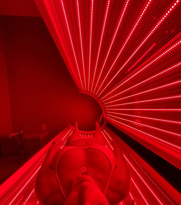 A guest lying in a red light therapy bed at A Hot Place To Chill in New Buffalo