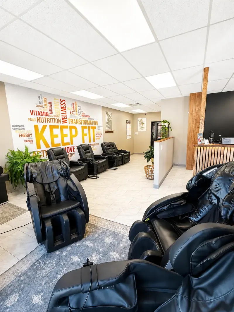Black robotic massage chairs in the bright, tiled lounge at A Hot Place To Chill in New Buffalo